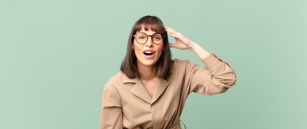 Jolie femme à l'air heureuse, étonnée et surprise, souriante et réalisant de bonnes nouvelles incroyables et incroyables