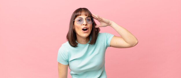 Jolie femme à l'air heureuse, étonnée et surprise, souriante et réalisant de bonnes nouvelles incroyables et incroyables