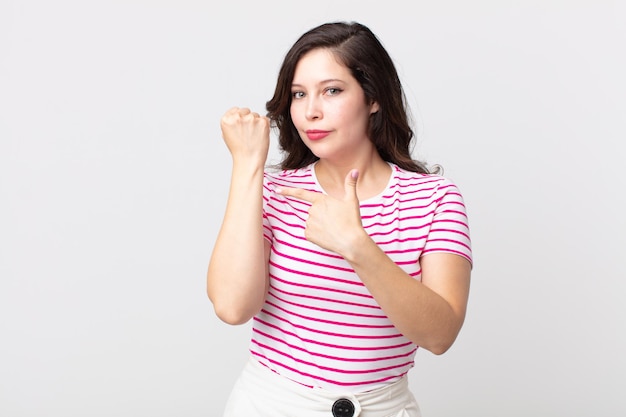 Jolie femme à l'air impatiente et en colère, pointant la montre, demandant la ponctualité, veut être à l'heure