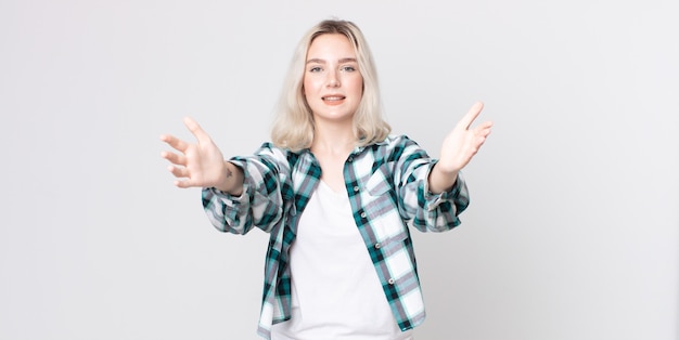 Jolie femme albinos souriant joyeusement donnant un câlin de bienvenue chaleureux, amical et affectueux, se sentant heureuse et adorable