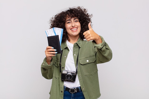 Jolie femme arabe avec un avion et des billets d'embarquement. concept de voyage