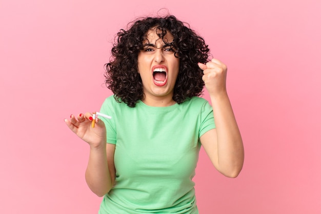 Jolie femme arabe criant agressivement avec une expression de colère. concept non fumeur