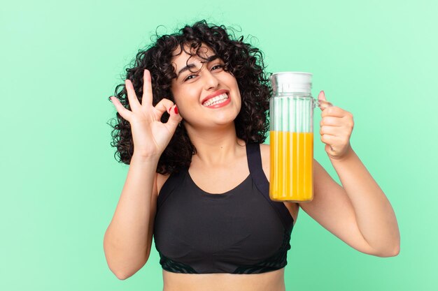 Jolie femme arabe avec du jus d'orange. concept de petit-déjeuner sain