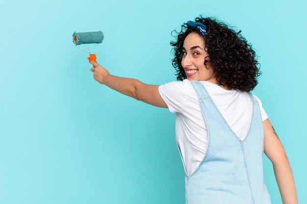 Jolie femme arabe peignant le concept de mur de maison