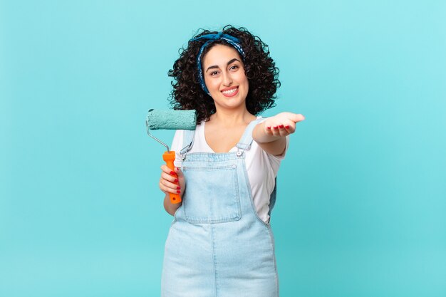 jolie femme arabe souriante joyeusement avec amicale et offrant et montrant un concept. concept de maison de peinture