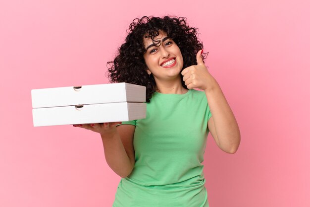 Jolie femme arabe tenant une boîte à pizza