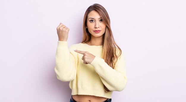 Jolie femme asiatique à l'air impatiente et en colère, pointant la montre, demandant la ponctualité, veut être à l'heure