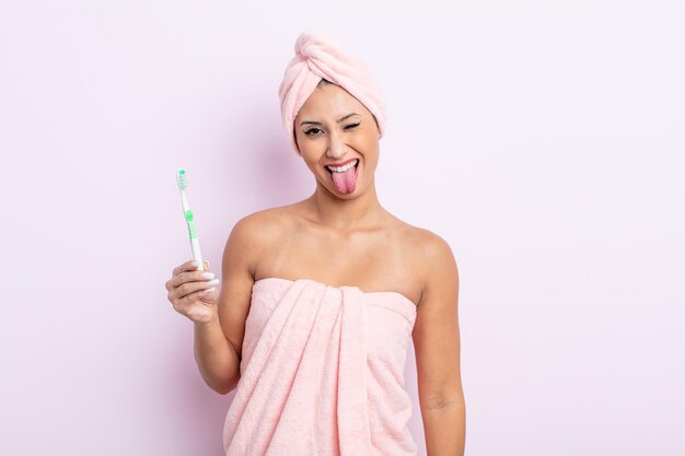 Jolie femme asiatique avec une attitude joyeuse et rebelle, plaisantant et tirant la langue. notion de brosse à dents