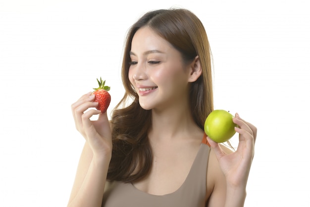 Jolie femme asiatique aux pommes et aux fraises