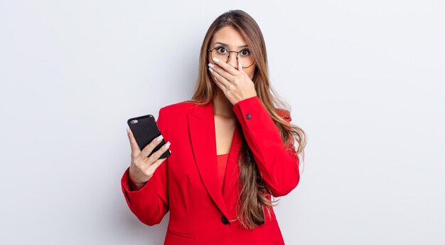 Jolie femme asiatique couvrant la bouche avec les mains avec un choc. concept d'entreprise et de téléphone.