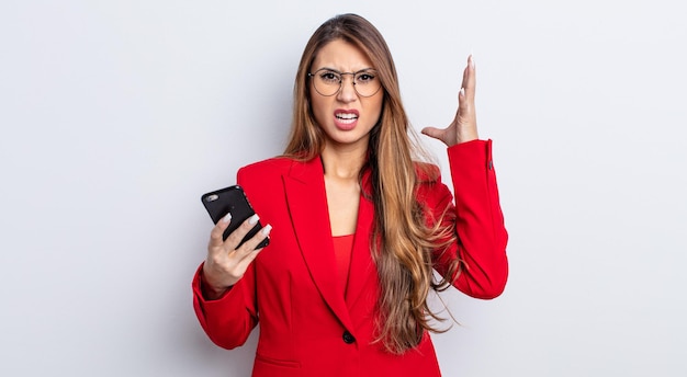 Jolie femme asiatique criant avec les mains en l'air. concept d'entreprise et de téléphone.