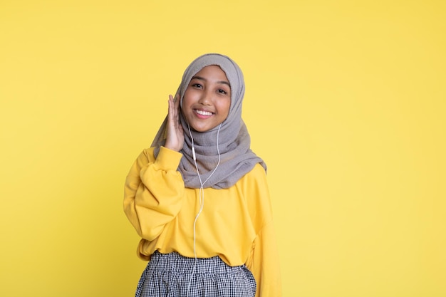 jolie femme asiatique écoutant de la musique sur fond jaune