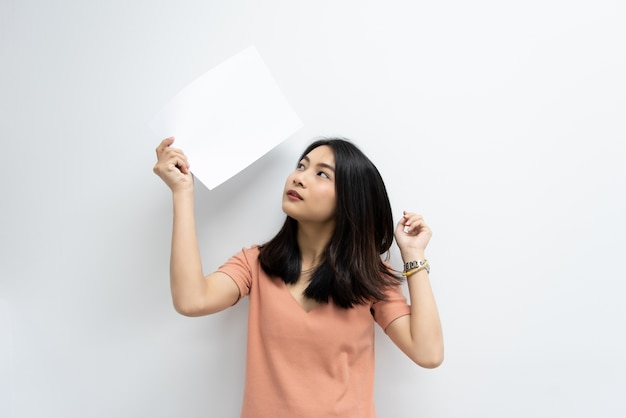 Jolie femme asiatique montrant du papier blanc vierge