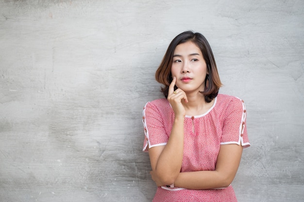 La jolie femme asiatique pense à quelque chose