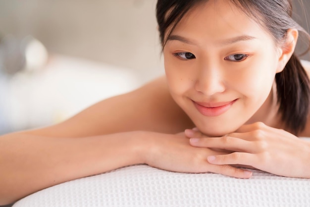 Jolie femme asiatique profiter et palourdes thérapie de massage oriental lit blanc concept d'idées de vie saine