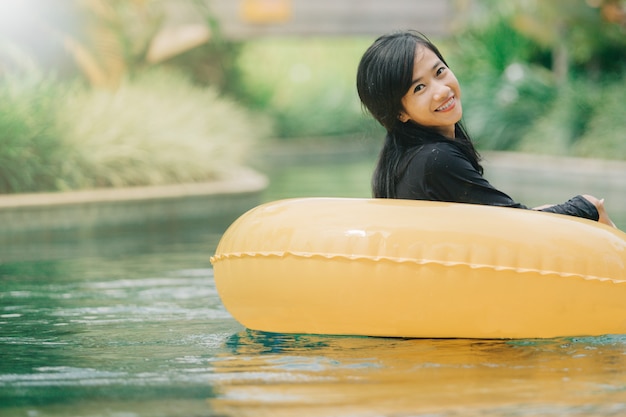 Jolie femme asiatique se détendre à la piscine de la rivière