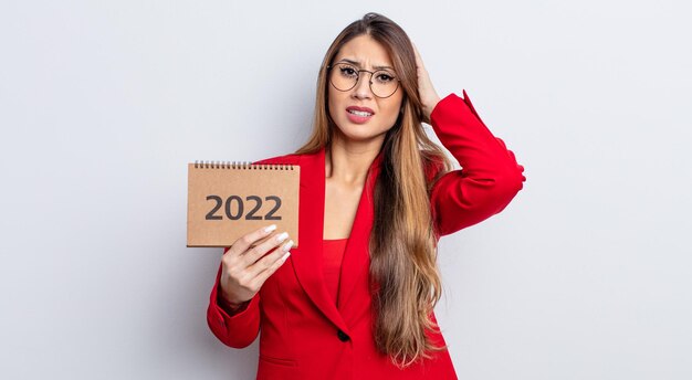 Jolie femme asiatique stressée, anxieuse ou effrayée, les mains sur la tête. notion de calendrier