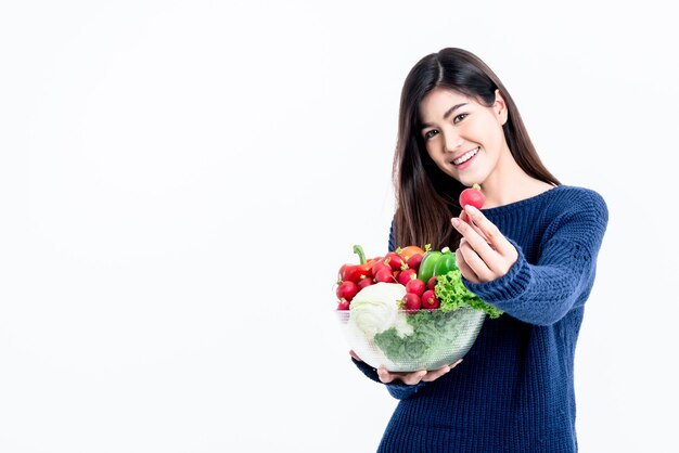 Jolie femme asiatique tenant un bol en verre contient des fruits et des légumes frais sur fond blanc