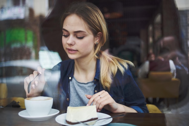 Jolie femme assise à la table dans le style de vie de snack petit déjeuner café