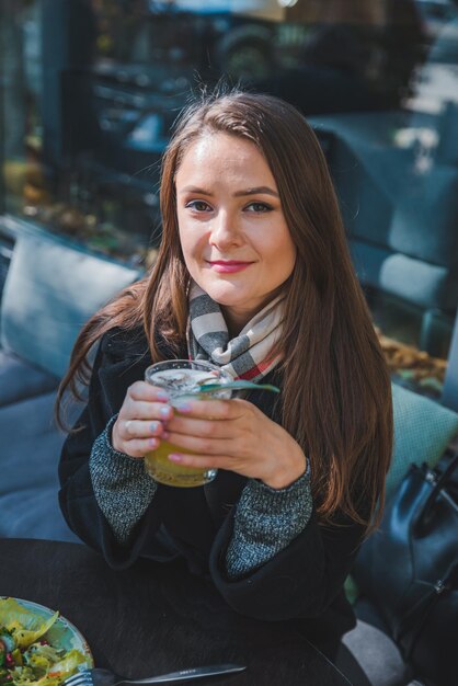 Jolie femme au café en plein air mangeant de la salade