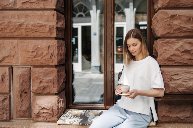 Jolie femme au café regarde la tasse de café