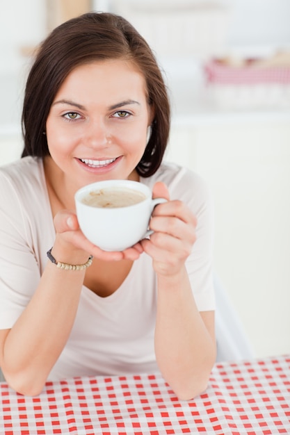 Jolie femme aux cheveux noirs, un café