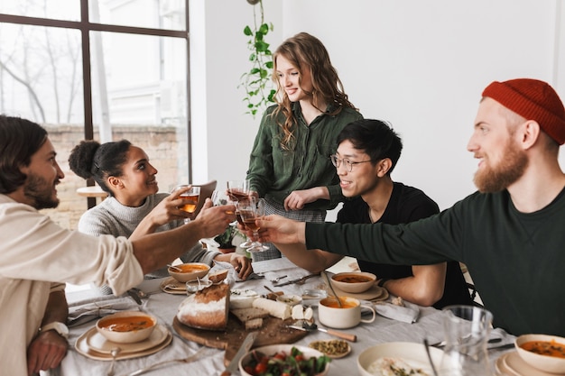 Jolie femme aux cheveux ondulés debout près de la table, passer du temps rêveur avec des collègues