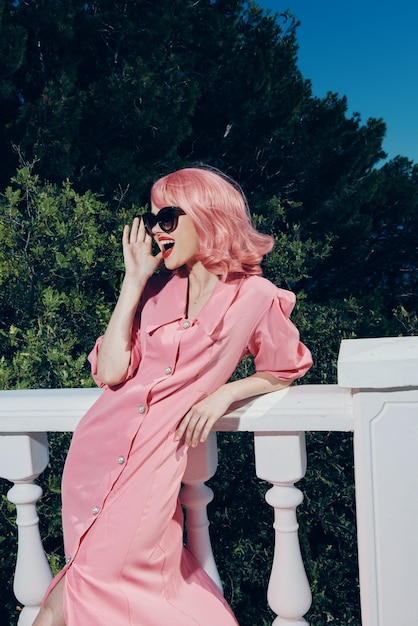 Jolie femme aux cheveux roses portant des lunettes de soleil posant jour d'été