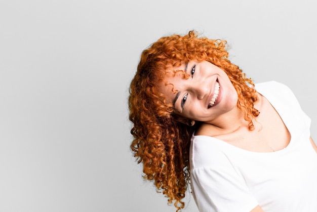 Jolie femme aux cheveux roux avec un espace de copie sur le côté présentant quelque chose