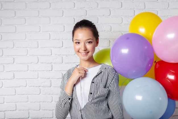 Jolie femme avec des ballons colorés