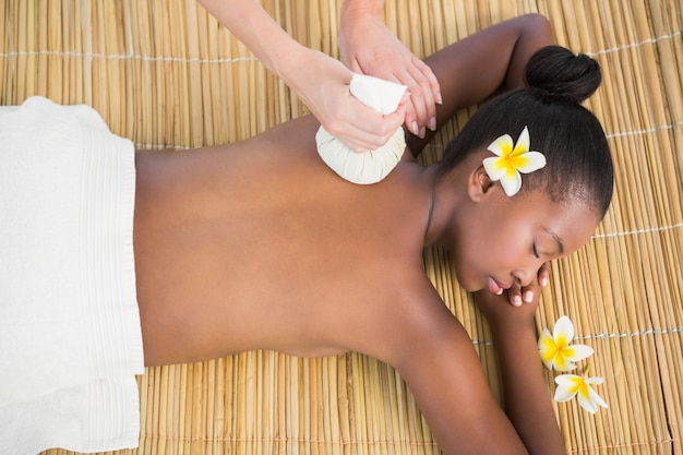 Jolie femme bénéficiant d&#39;un massage aux compresses à base de plantes