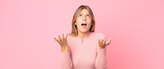 jolie femme blonde à l'air désespérée et frustrée, stressée, malheureuse et agacée, criant et hurlant