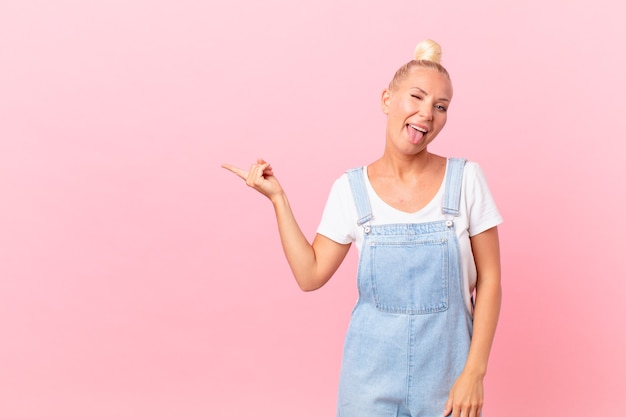 Jolie femme blonde avec une attitude joyeuse et rebelle, plaisantant et tirant la langue