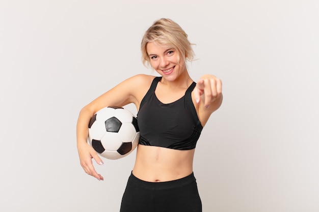 Jolie femme blonde avec un ballon de football