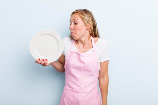 Jolie femme blonde avec un concept de chef de plat vide