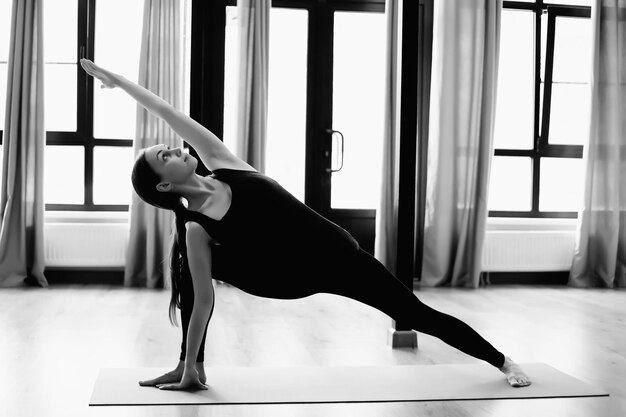 Jolie femme blonde avec un corps parfait dans un vêtement de sport debout dans une pose de yoga. Concept de mode de vie sain sportif, de nutrition et d'entraînement.