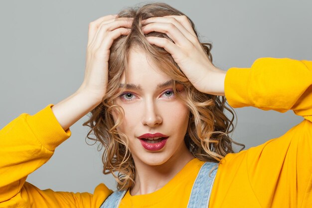 Une jolie femme blonde sur un fond gris.