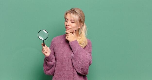 Jolie femme blonde avec une loupe