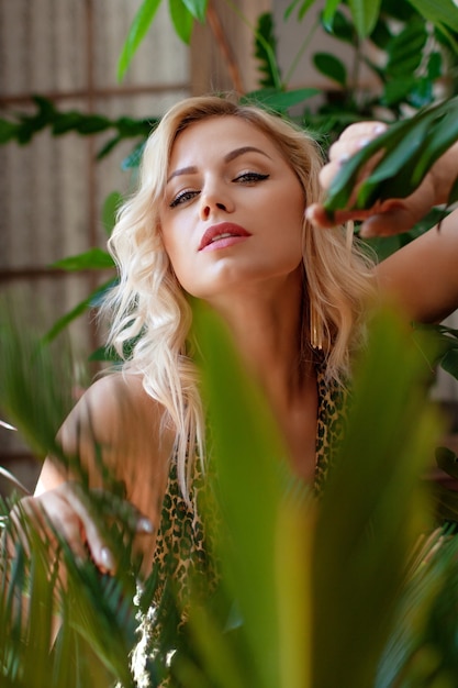 Jolie femme blonde et plantes à la maison