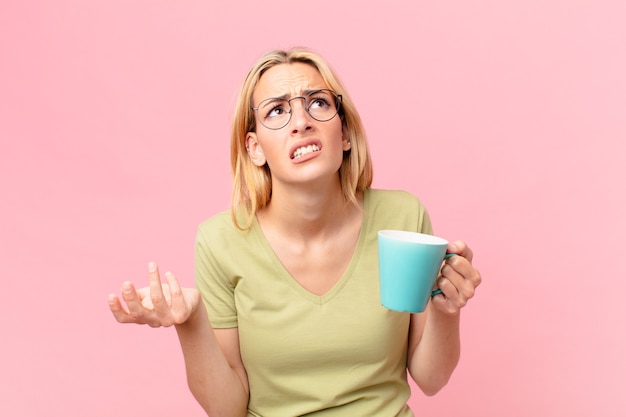 Jolie femme blonde prenant un café