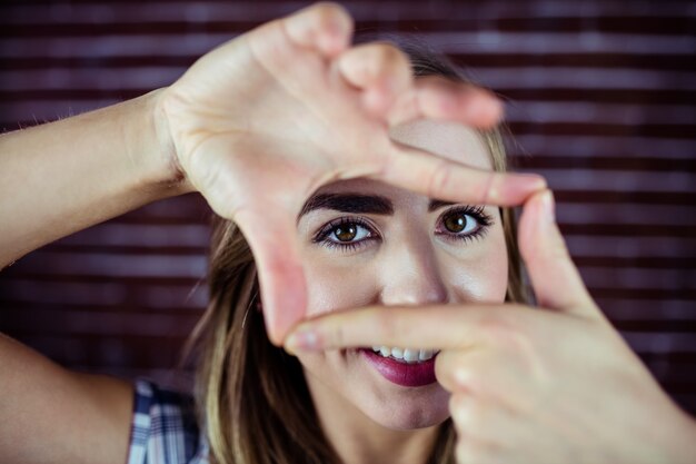 Photo jolie femme blonde regardant à travers ses mains