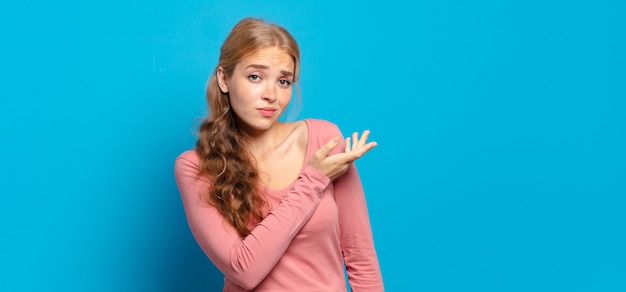 Photo jolie femme blonde se sentant confuse et désemparée, s'interrogeant sur une explication ou une pensée douteuse