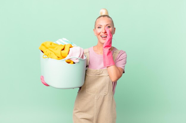 Jolie femme blonde se sentant heureuse, donnant un grand cri avec les mains à côté du concept de vêtements pour se laver la bouche