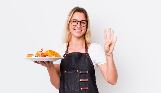 Jolie femme blonde souriante et amicale montrant le concept de gaufres numéro quatre