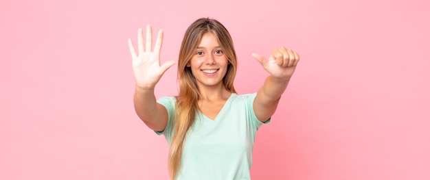 Jolie femme blonde souriante et semblant amicale, montrant le numéro six ou sixième avec la main vers l'avant, compte à rebours