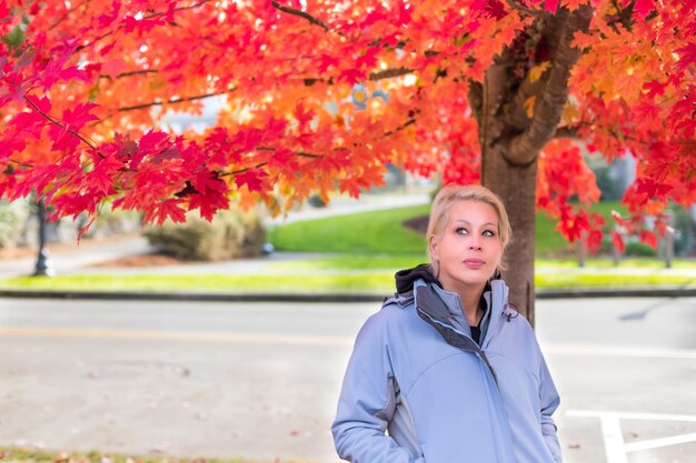 Jolie femme blonde sous l'arbre d'automne automne