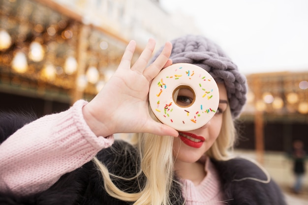 Jolie femme blonde tenant un délicieux biscuit au pain d'épice