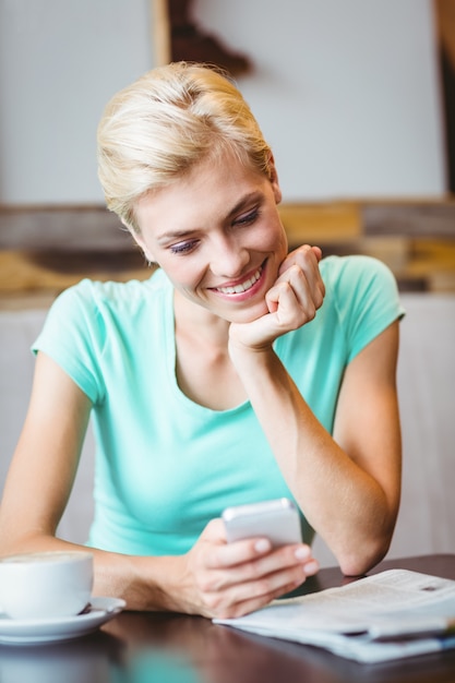 Jolie femme blonde utilisant son smartphone