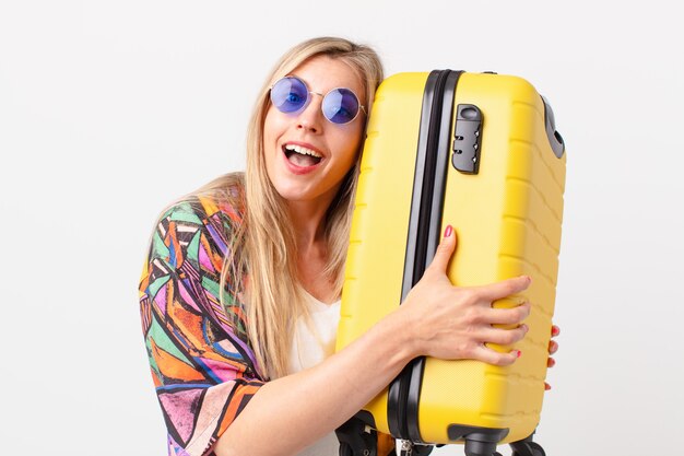 jolie femme blonde avec une valise. concept d'été