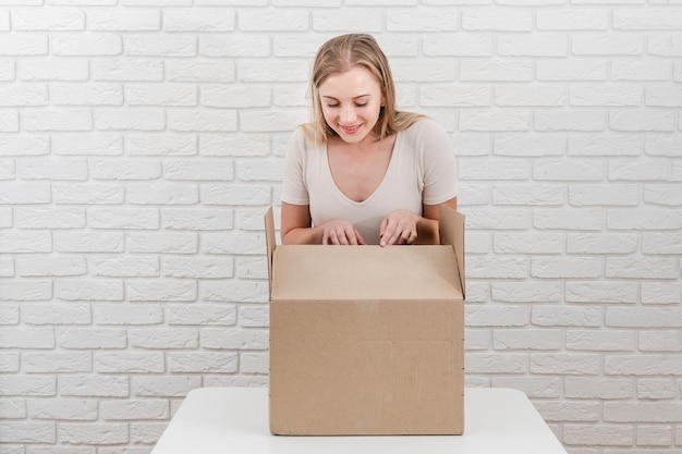 Jolie femme avec une boîte en carton ouverte Livrer un colis